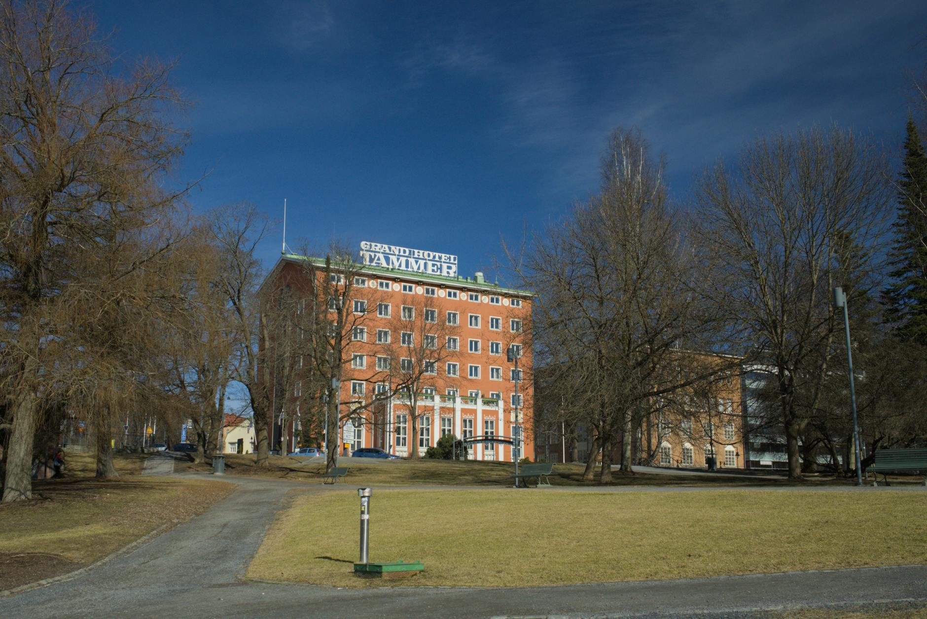 Grand Hotel Tammer w Tampere otoczony drzewami w słoneczny dzień