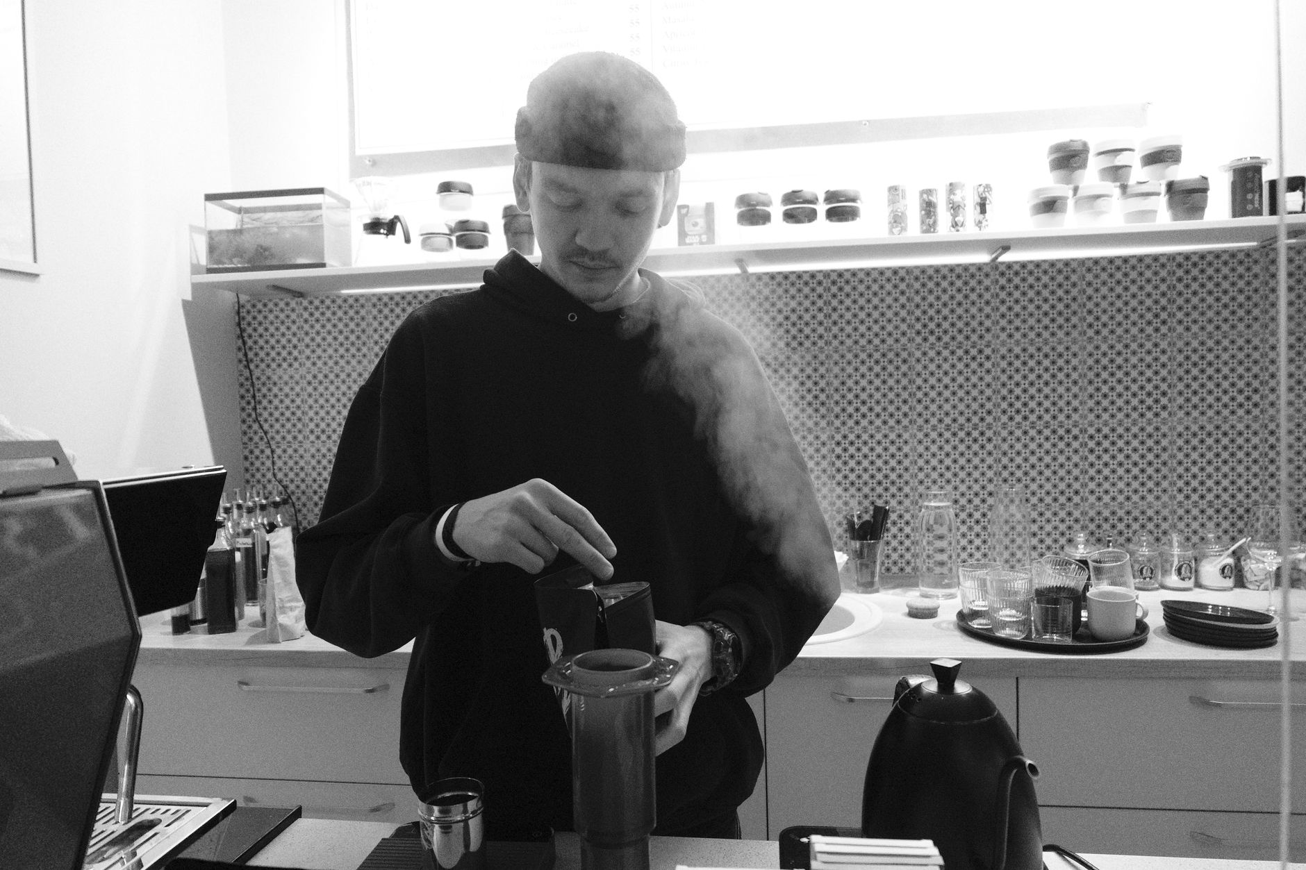 Barista parzy świeżą kawę w nowoczesnej kuchni Aeropressem