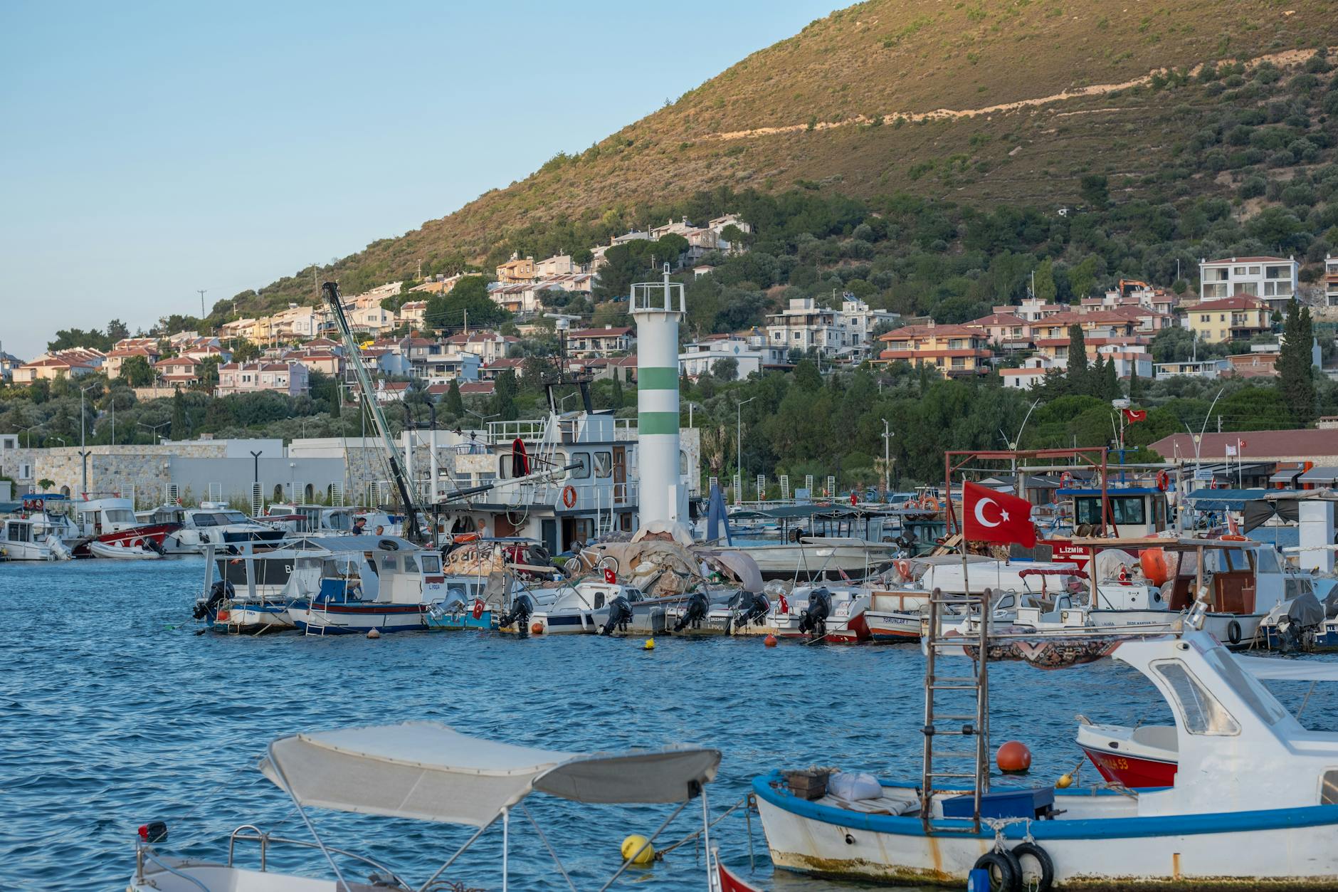 Marina Yenifoca w Izmirze z zacumowanymi łódkami i pagórkowatym tłem