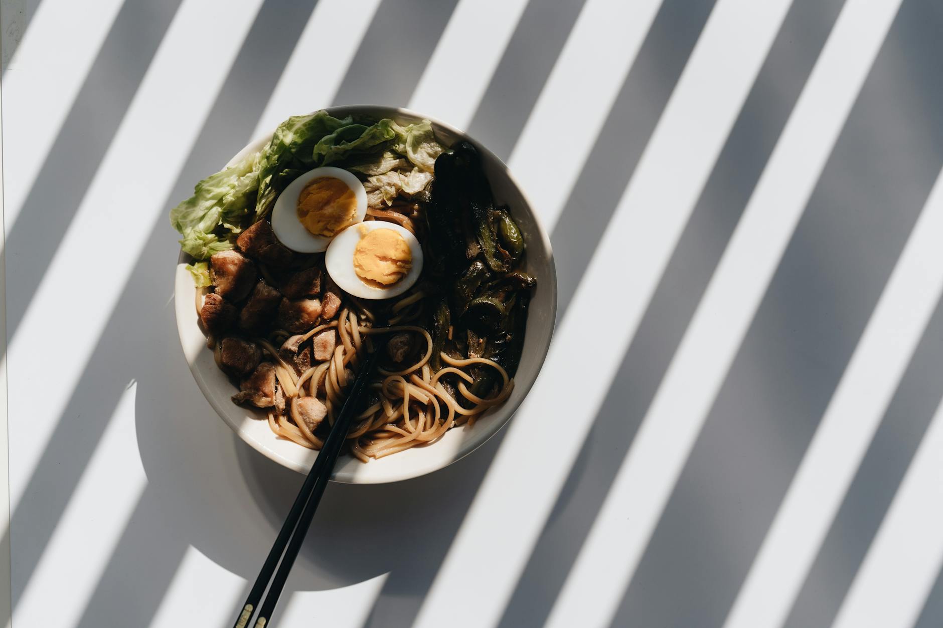 Jak przygotować domowy ramen krok po kroku – prosty przepis i praktyczne wskazówki Miska domowego ramenu z jajkiem, mięsem i zieleniną w mocnym świetle