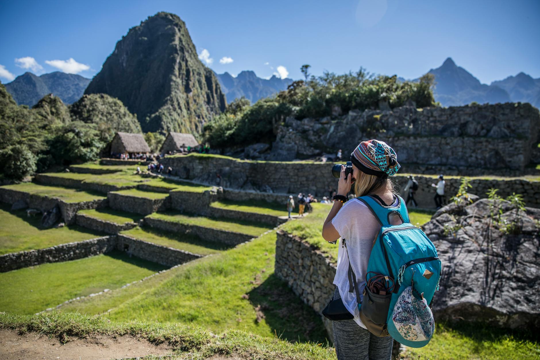 Jak przygotować samodzielną podróż po Ameryce Południowej: praktyczny przewodnik krok po kroku Podróżnik fotografuje Machu Picchu w słoneczny dzień w Peru