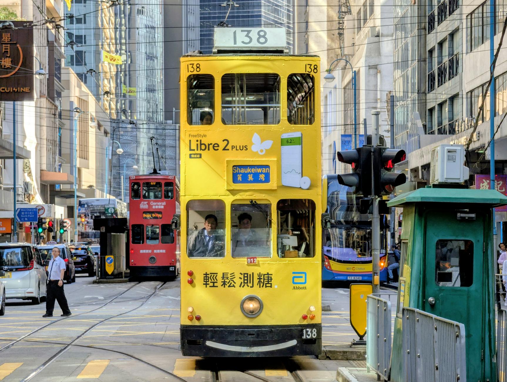 Żółty tramwaj wśród zatłoczonych ulic i wieżowców Hongkongu