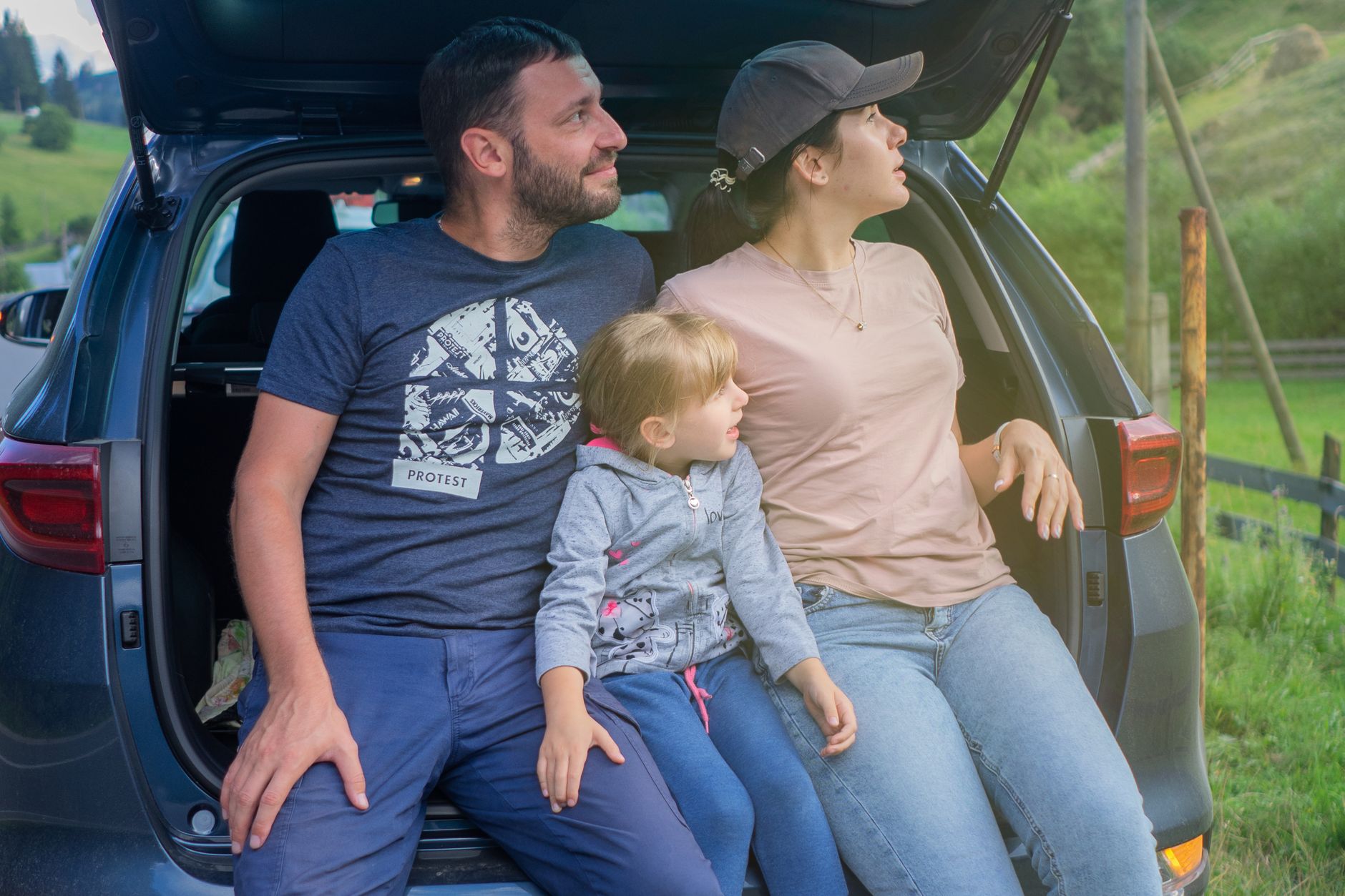 Najlepsze używane kombi do 35 tys. zł dla rodziny i na długie trasy Rodzina siedzi w bagażniku kombi podczas wyjazdu za miasto