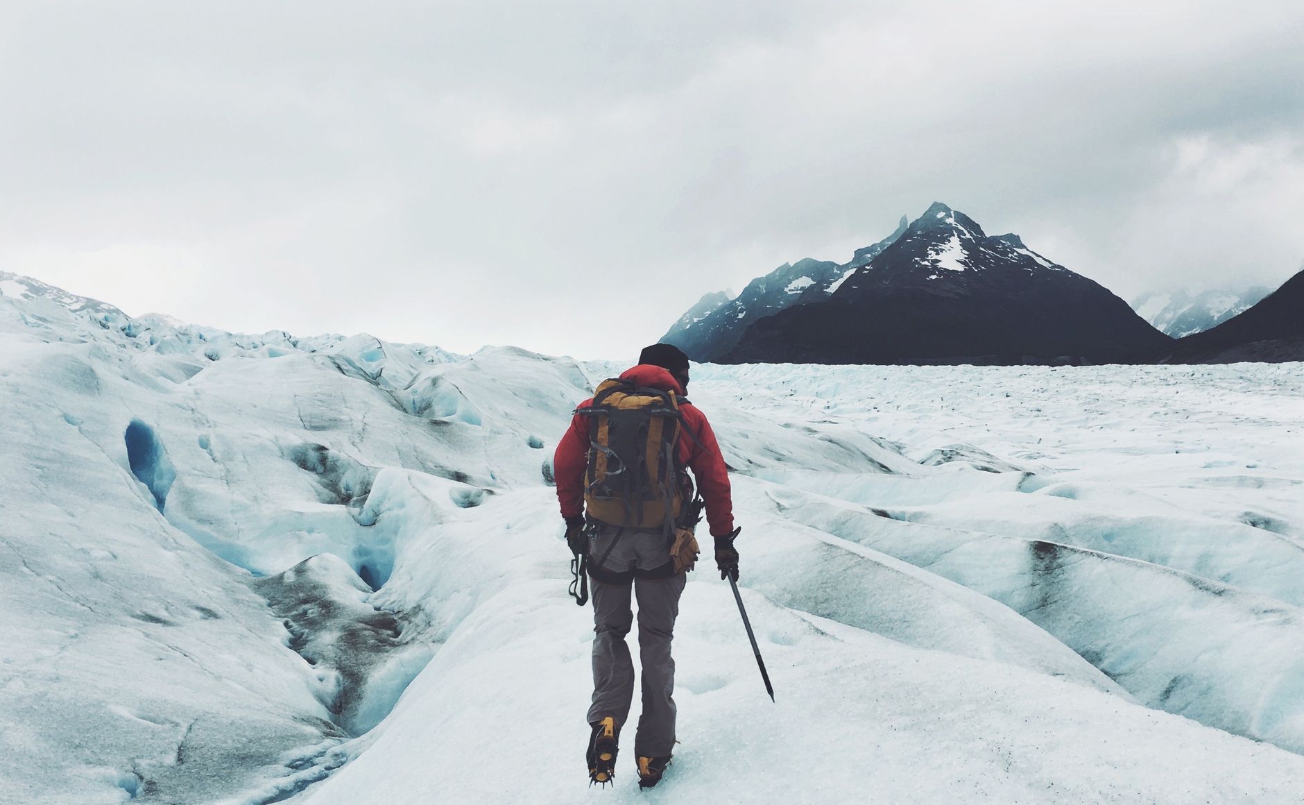 Trekker idący samotnie po zaśnieżonym lodowcu w Patagonii