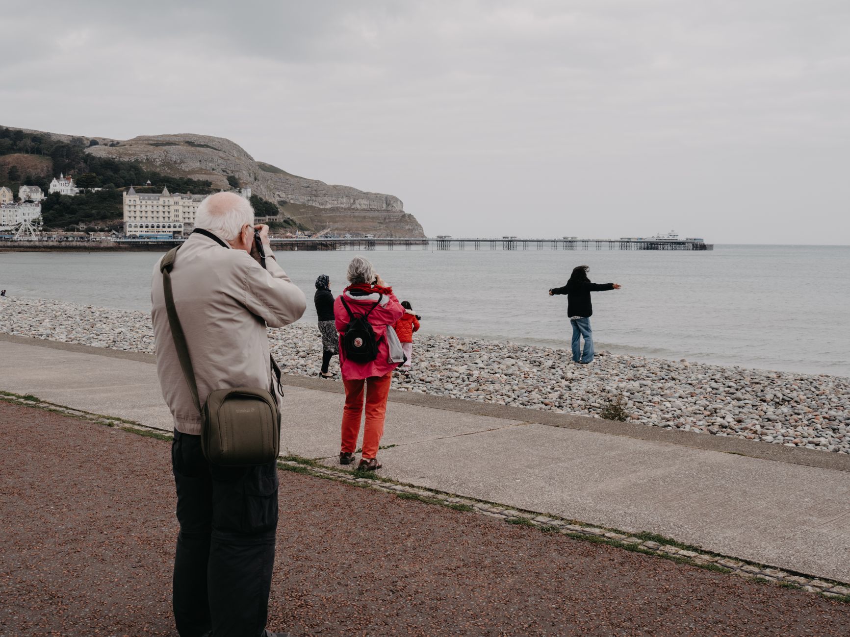 Turyści fotografują wybrzeże Llandudno w chłodny dzień w Walii