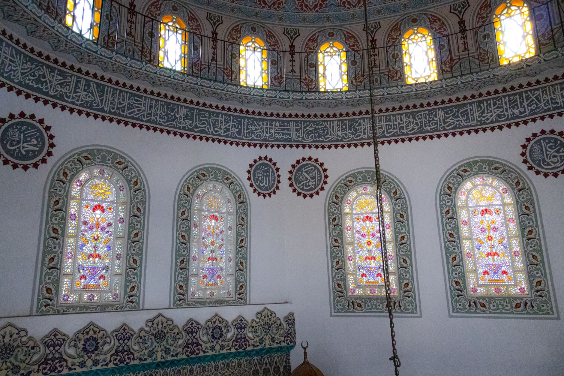 Wnętrze meczetu w Stambule z witrażami i islamską kaligrafią